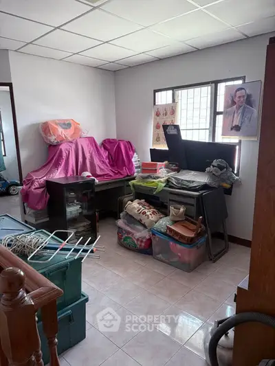 Cluttered storage room with various household items and boxes.