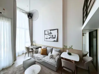 Modern living room with high ceilings and stylish decor in a loft apartment.