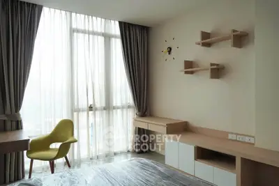 Modern bedroom with stylish furniture and large window offering natural light