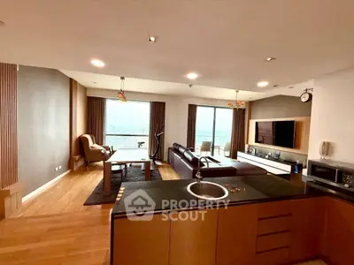 Spacious modern living room with open kitchen and stunning city view.