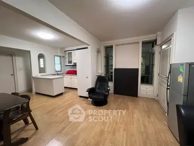 Spacious open-plan living area with modern kitchen and wooden flooring.