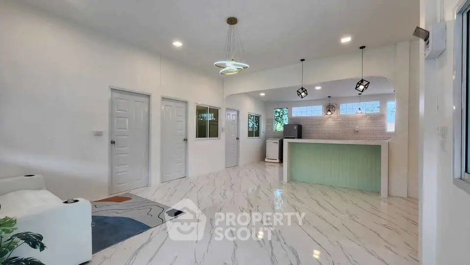 Modern open-plan living room with stylish kitchen and marble flooring