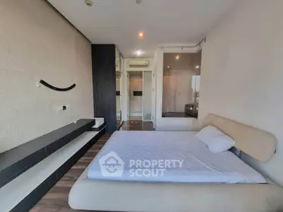 Modern bedroom with minimalist design and large window for natural light.