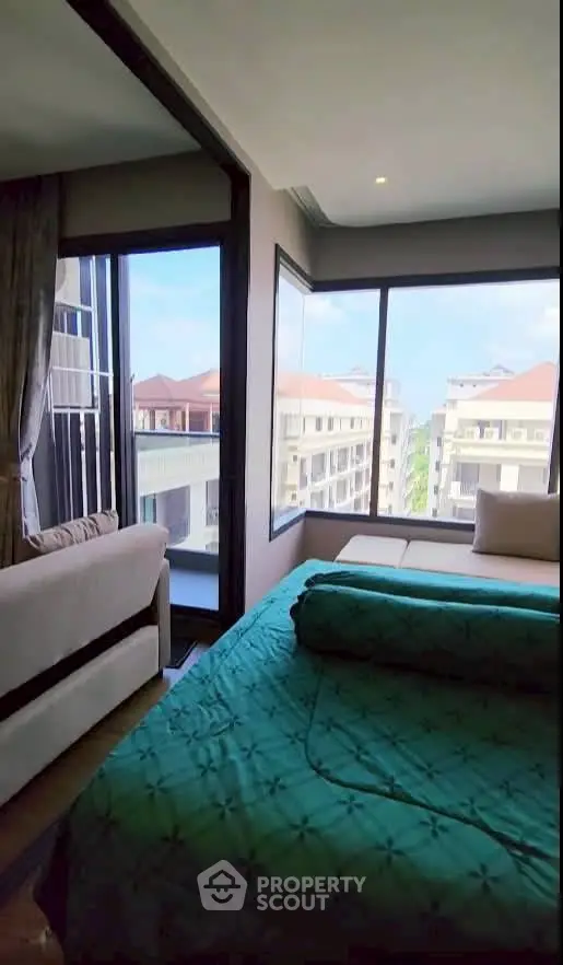 Luxurious bedroom with stunning city view and cozy seating area.