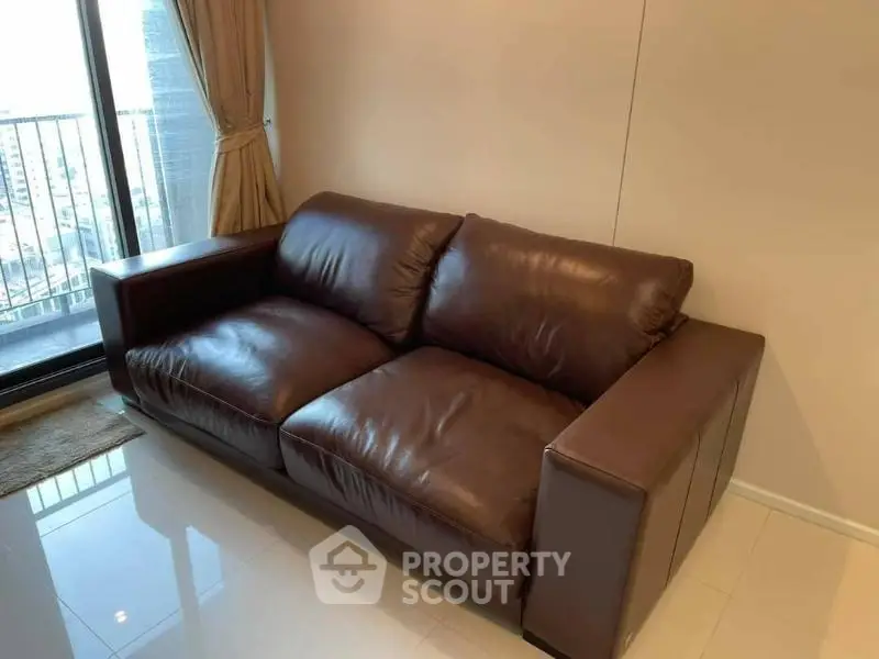 Luxurious brown leather sofa in modern living room with city view balcony.