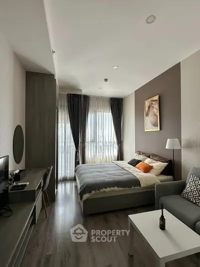Modern bedroom with stylish decor, large windows, and cozy ambiance in a contemporary apartment.