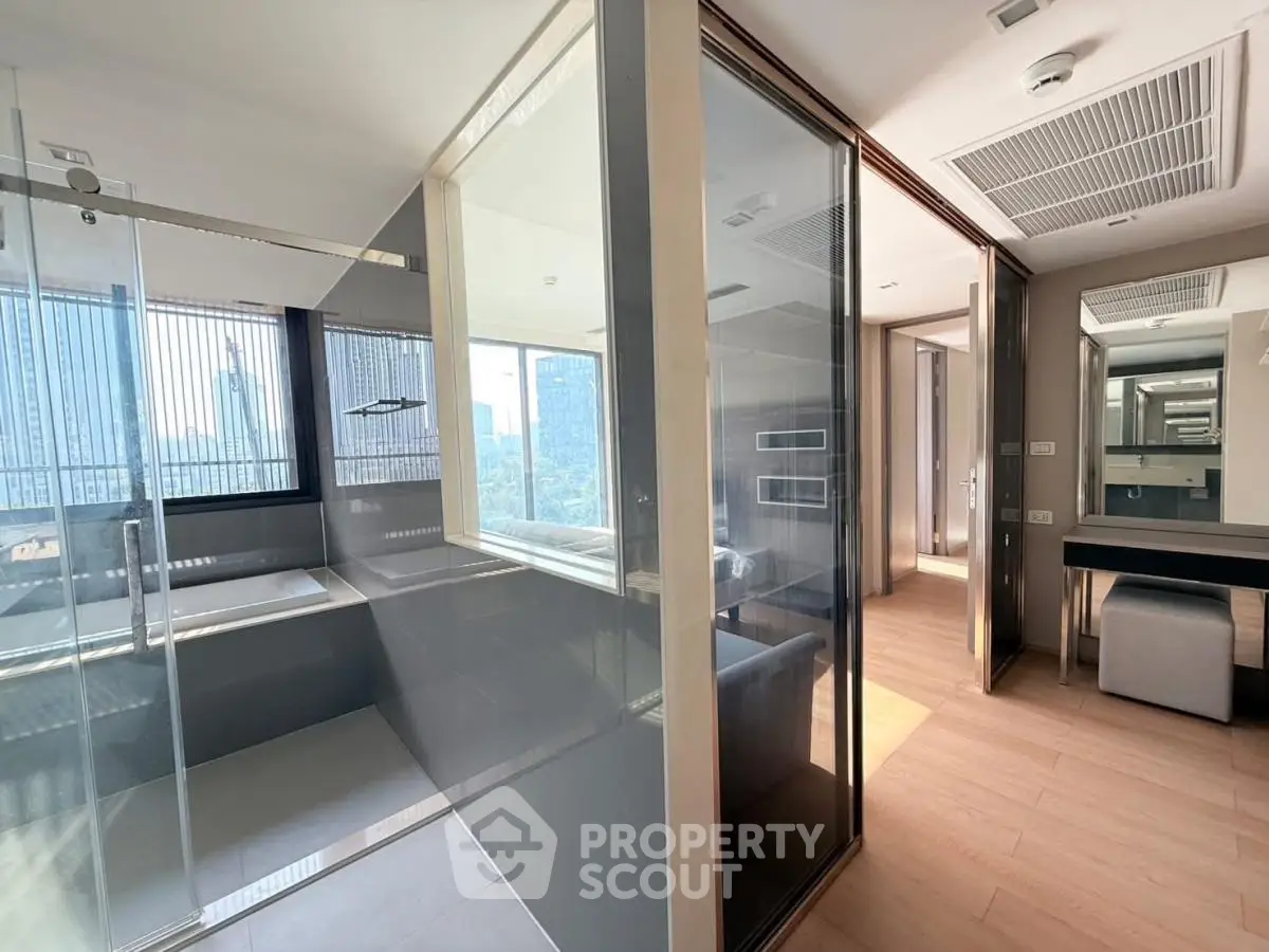 Modern apartment interior with glass shower and city view