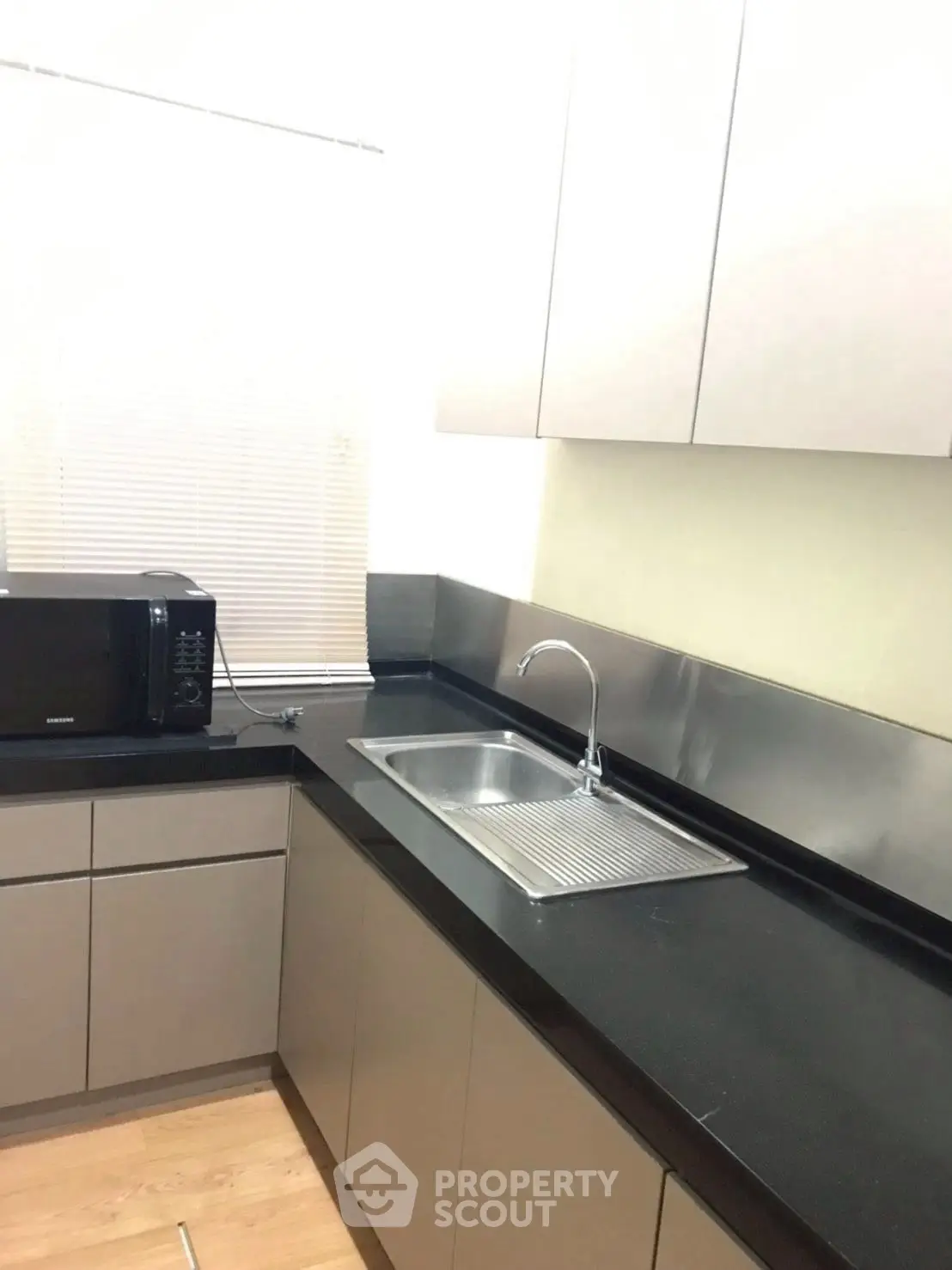 Modern kitchen with sleek black countertops and built-in microwave