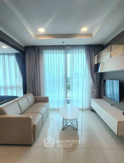 Modern living room with large windows and stylish furniture, offering a bright and inviting atmosphere.