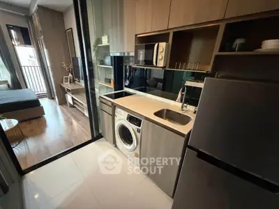 Modern compact kitchen with washing machine and fridge in stylish apartment