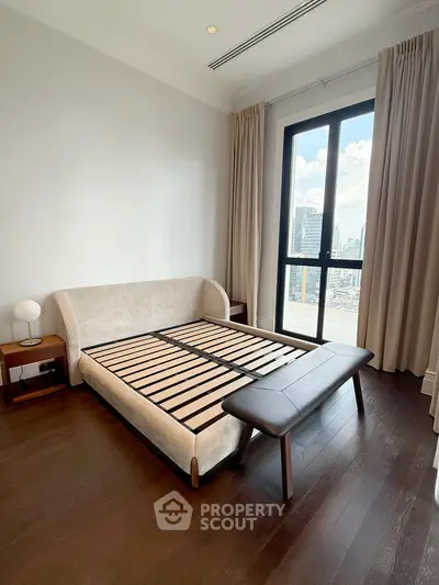Modern bedroom with city view, featuring a stylish bed frame and elegant decor.