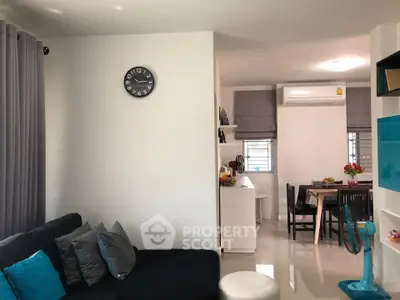 Modern living room with dining area, featuring sleek furniture and stylish decor.