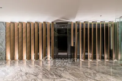 Luxurious modern building entrance with elegant marble flooring and stylish wooden paneling.