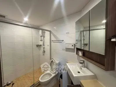 Modern bathroom with glass shower and sleek fixtures in a contemporary home.