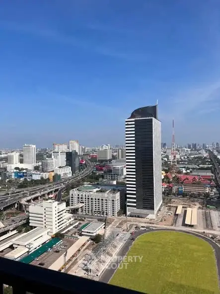 Stunning cityscape view from a high-rise balcony showcasing modern architecture and vibrant urban life.