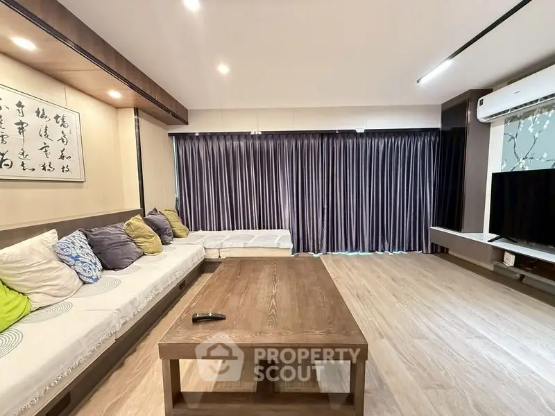 Spacious living room with modern decor and large sofa, perfect for relaxation.