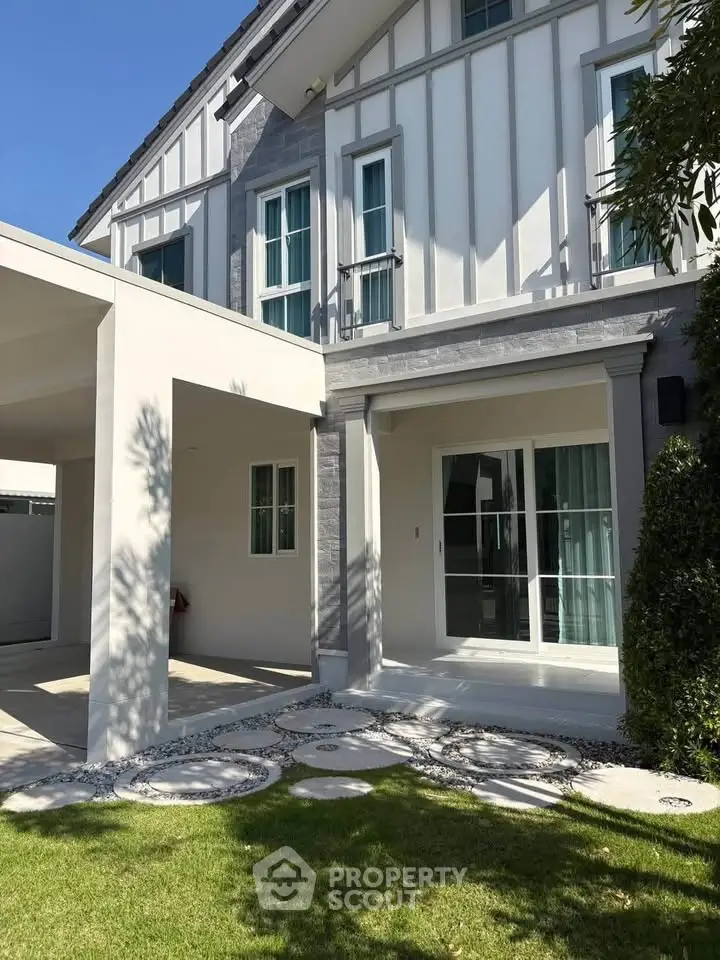 Charming modern house exterior with lush green lawn and stylish architecture.