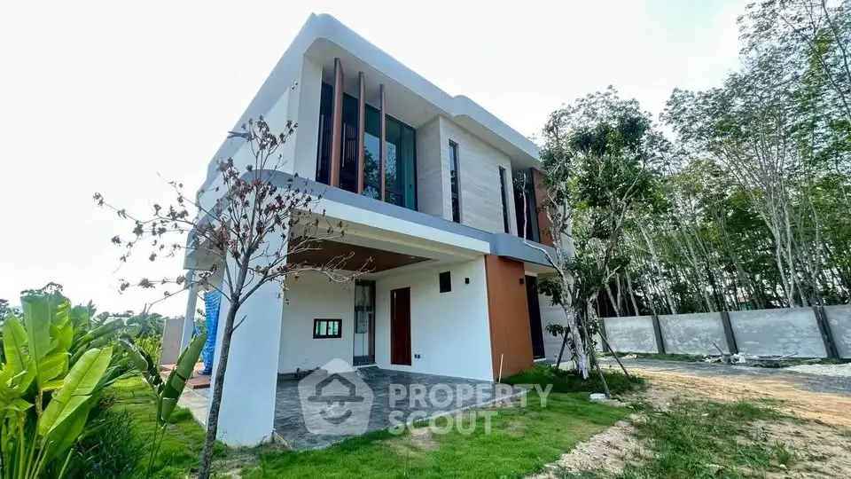 Modern two-story house with sleek design and lush greenery, perfect for contemporary living.