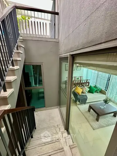 Modern multi-level home with stylish staircase and cozy living room view.