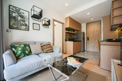 Modern living room with cozy sofa and open kitchen layout in stylish apartment.