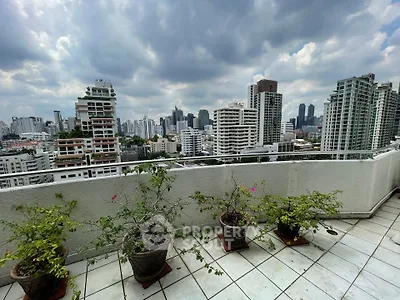 Stunning cityscape view from a spacious balcony with potted plants and skyline backdrop.