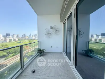 Spacious balcony with stunning city skyline view and modern glass railing.