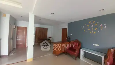 Spacious living room with elegant furniture and butterfly wall decor in modern apartment.