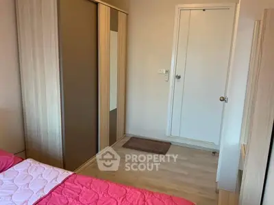 Cozy bedroom with wooden flooring and built-in wardrobe, perfect for modern living.