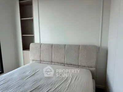 Modern bedroom with plush headboard and built-in shelving, perfect for stylish living.
