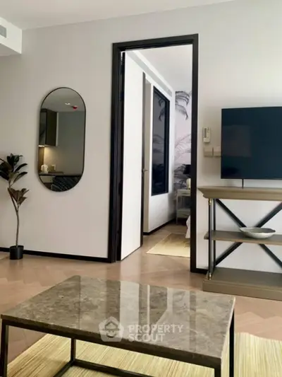 Modern living room with stylish decor and open doorway to bedroom