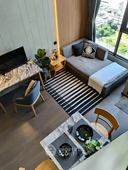 Modern living room with stylish decor and large window offering city view