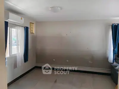 Spacious empty room with large windows and air conditioning, ready for customization.