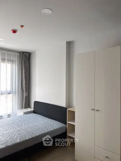 Modern bedroom with sleek furniture and natural light in a stylish apartment.