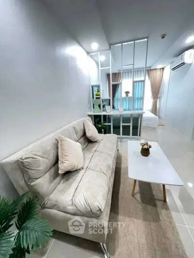 Modern open-plan living room with cozy sofa and stylish decor in a bright apartment.