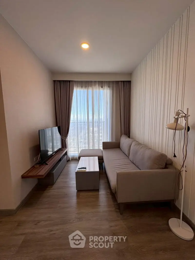 Modern living room with stylish sofa, floor lamp, and large window offering a stunning city view.