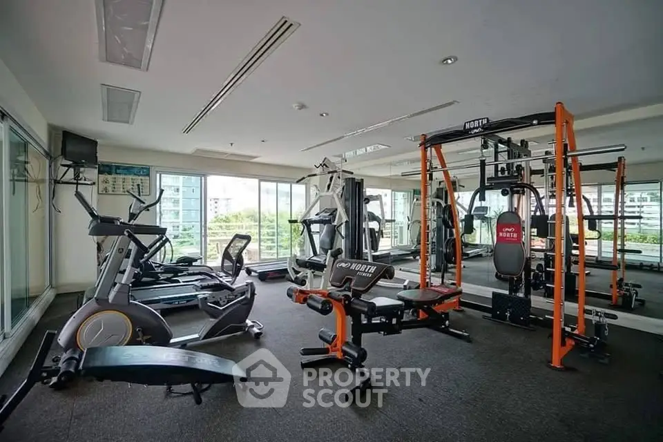Modern gym with state-of-the-art fitness equipment and large windows offering a scenic view.