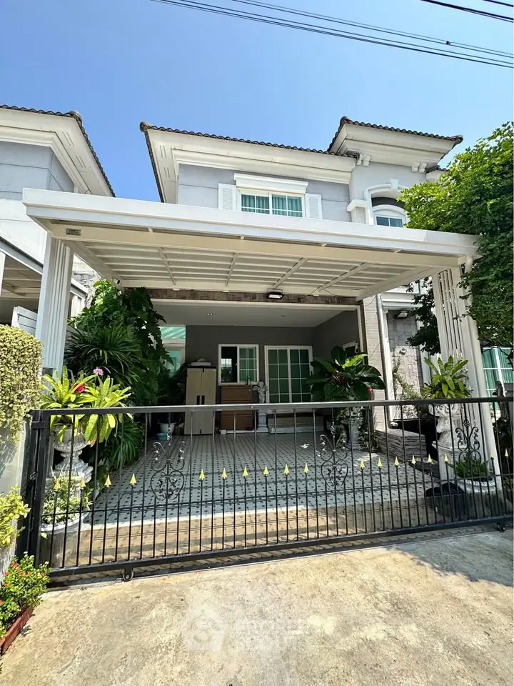 Charming two-story house with a spacious driveway and lush greenery, perfect for family living.