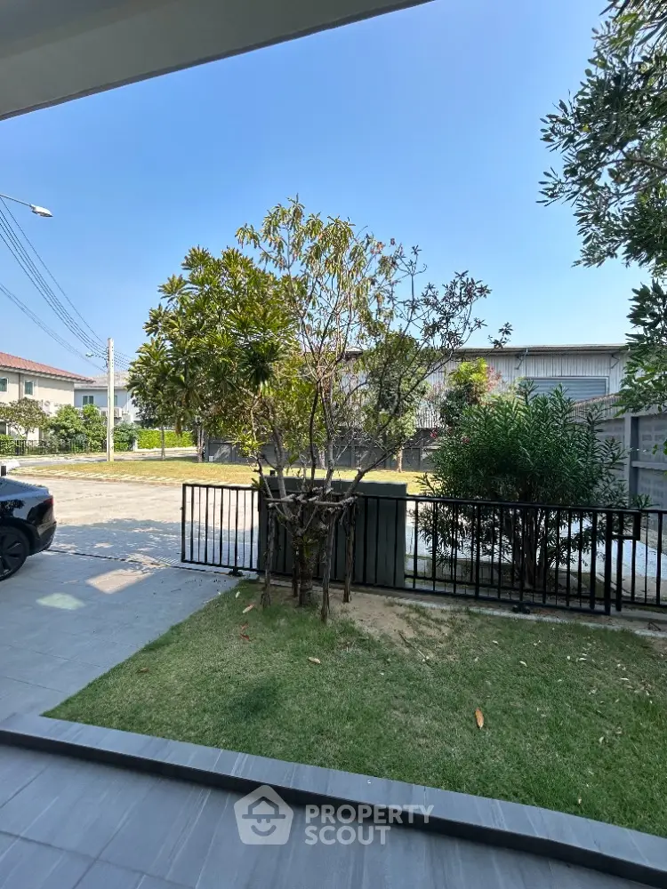 Spacious and serene outdoor view from a covered patio, showcasing lush greenery and a well-maintained lawn, perfect for tranquil living.