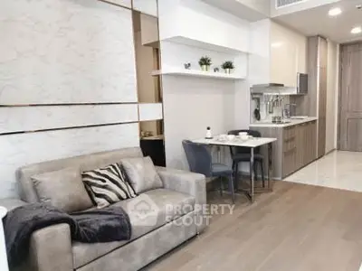 Modern open-layout living room with cozy sofa and stylish kitchen area