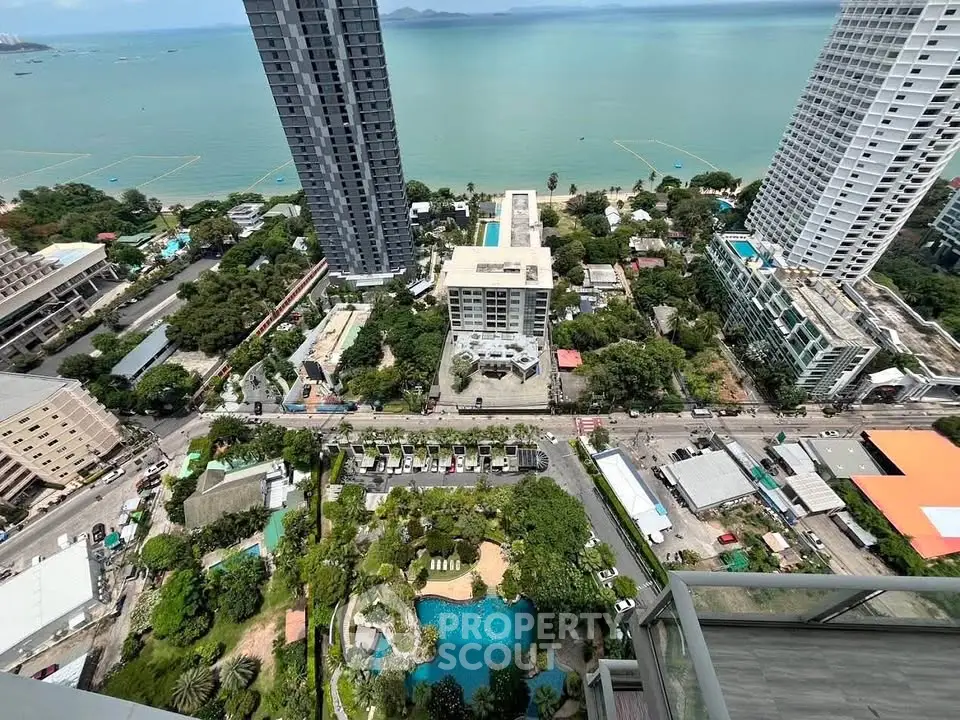 Stunning high-rise view of coastal cityscape with ocean backdrop, showcasing modern architecture and lush greenery.
