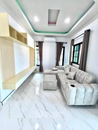 Modern living room with stylish sofa and built-in shelving, featuring elegant marble flooring and ambient lighting.