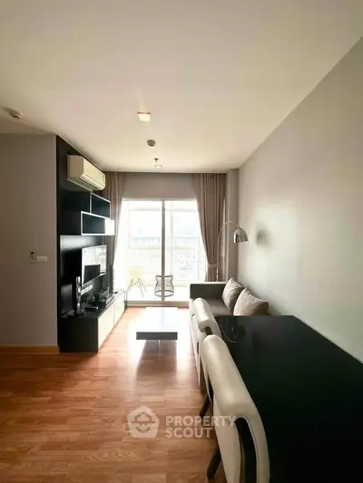 Modern living room with sleek furniture and large window offering natural light.