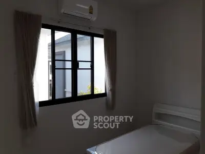 Cozy bedroom with natural light and air conditioning, ideal for comfortable living.