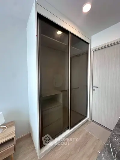Modern bedroom with sleek sliding door wardrobe and wooden flooring