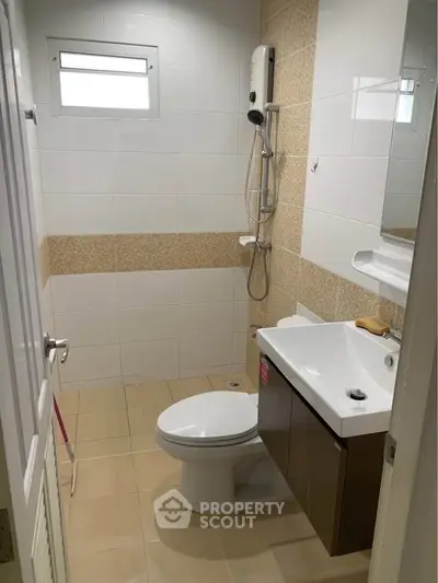Modern bathroom with shower, sink, and toilet in a compact layout.