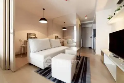 Modern living room with sleek white furniture and stylish lighting in a contemporary apartment.