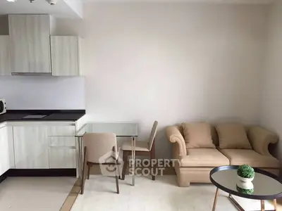 Modern living room with cozy sofa and stylish kitchen area in open layout apartment.