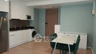 Modern kitchen with sleek white cabinets, integrated appliances, and stylish dining area.