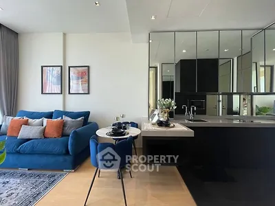 Modern living room with stylish blue sofa and elegant dining area in open layout apartment.