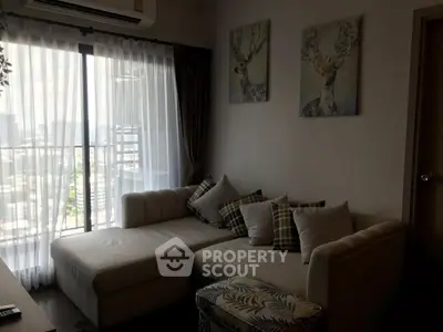 Cozy living room with stylish decor and city view from large window.